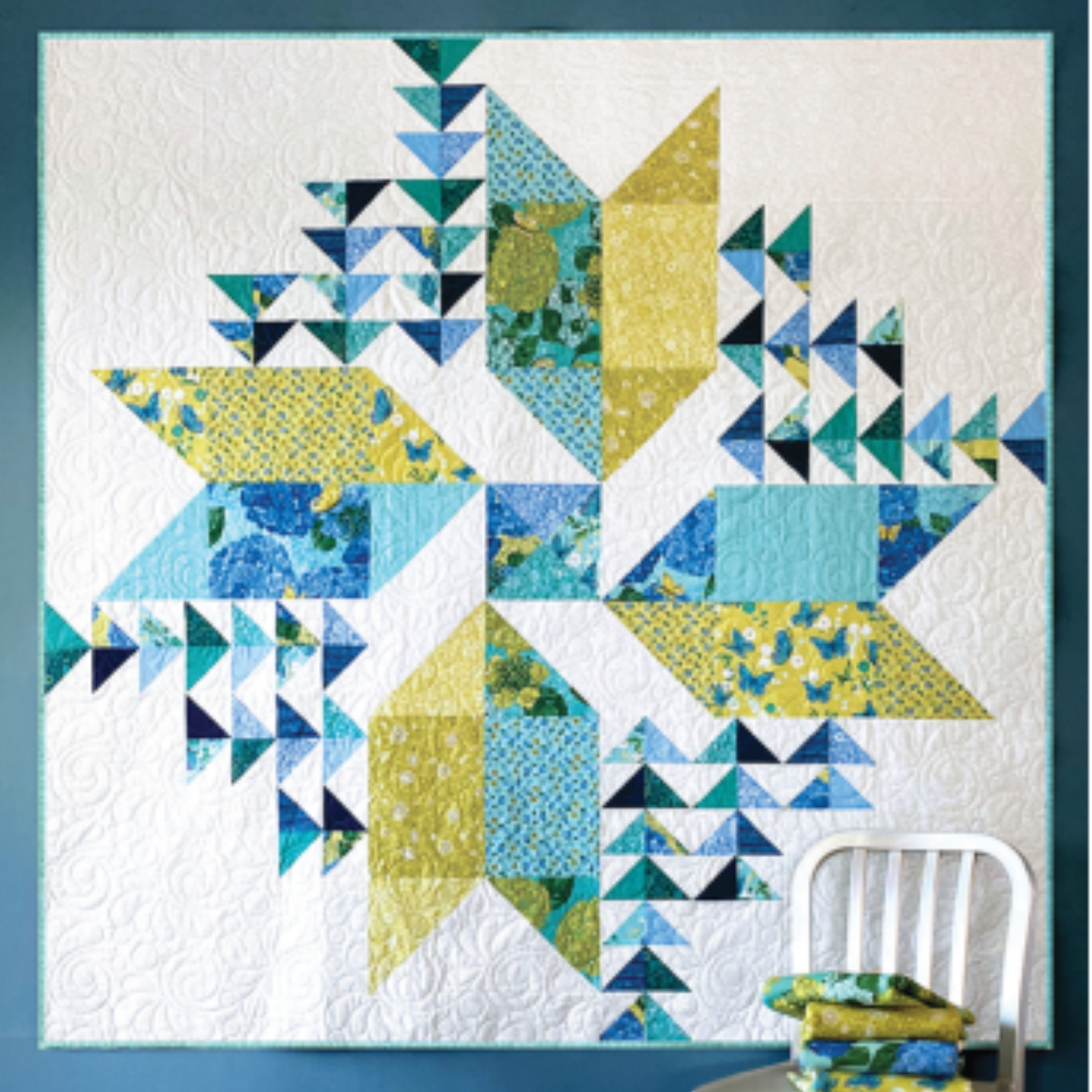 Photo showing the Sprindrift quilt pattern on a white backing with varying green and blue hued fabrics.
