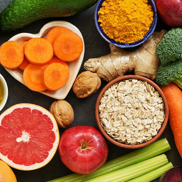  Table with assortment of food including grapefruit, carrots, lettuce, broccoli, and other fruits and vegetables.